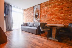 a living room with a couch and a brick wall at Apartamenty na Wyspie - Villa Mistral - Apartamenty z sypialnią i parkingiem in Świnoujście