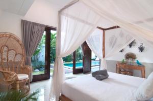 a bedroom with a bed and a chair and a desk at 3BR Villa Olli - Minggu Villas in Kerobokan