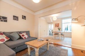 a living room with a couch and a table at Radford Place - Central Exeter - Patio & Garden - Beach - Chiefs - Uni -WiFi in Exeter