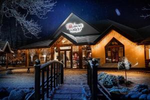un edificio con una tienda en la nieve por la noche en Turiyske Podvir'ya, en Blazhennik