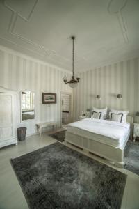 biała sypialnia z dużym łóżkiem i dywanem w obiekcie Káli Art Inn w mieście Köveskál