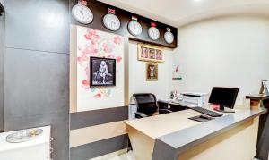 an office with a desk and clocks on the wall at Treebo Trend Saga Apartment in Bangalore