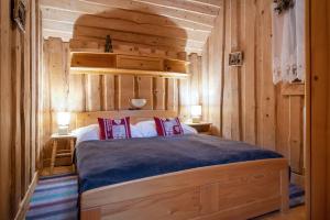 a bedroom with a bed in a room with wooden walls at Zariadenie v rekonštrukcii in Žiar