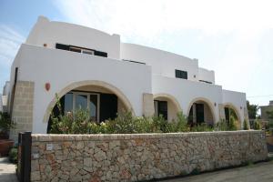 una casa bianca con un muro di pietra davanti di Apartment 3 With Pool And Sea View a Santa Maria al Bagno