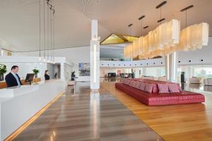 a red couch in the middle of a lobby at Hipotels Playa de Palma Palace&Spa in Playa de Palma