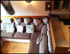 - un canapé brun avec des oreillers dans l'établissement Appartement chalet PRA LOUP 1600 La sapinière, à Pra-Loup
