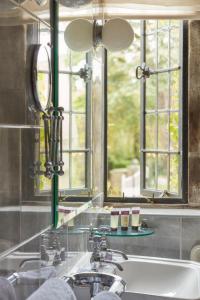 bagno con lavandino e specchio di Mallory Court Country House Hotel & Spa a Leamington Spa