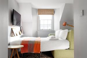 1 dormitorio con 1 cama, 1 silla y TV en Eden Locke, en Edimburgo