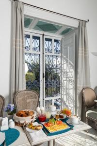 einen Tisch mit Frühstücksspeise darauf mit Fenster in der Unterkunft Dar Said in Sidi Bou Saïd