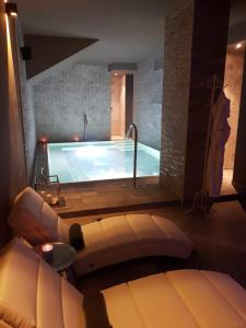 uma grande piscina num quarto com um sofá em Hotel Torre Antica em Loano