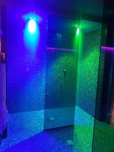 ロアーノにあるHotel Torre Anticaの紫と緑の照明、シャワー付きのバスルーム