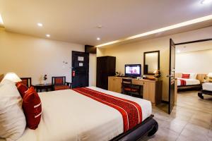 a hotel room with a bed and a television at Raming Lodge Hotel in Chiang Mai