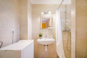 biała łazienka z umywalką i prysznicem w obiekcie BpR Cercle Point Apartment w Budapeszcie