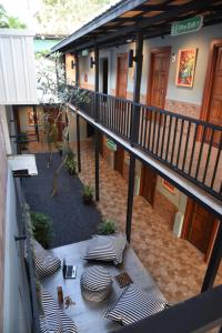 a balcony of a building with a courtyard with chairs at Zleepingpills Aonang Krabi in Krabi town