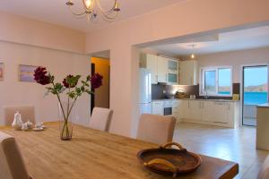 a dining room table with a vase of flowers on it at Kristallia - Elounda seafront vacation rental in Elounda