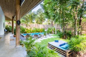 een achtertuin met een zwembad en een tuin met blauwe kussens bij DHYANA VILLAS in Hinkong