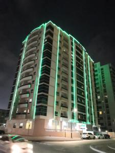 un gran edificio con luces verdes por la noche en Boulevard City Suites Hotel Apartments en Dubái