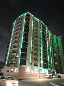 a large building with green lights on it at night at Boulevard City Suites Hotel Apartments in Dubai