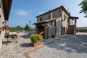 a small brick building with a bench and flowers at Villa Sofia - Homelike Villas in Amelia +30 photos
