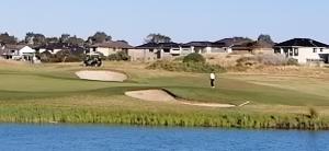 a man standing on a golf course next to the water at Melbourne Lakes warm house in Melbourne