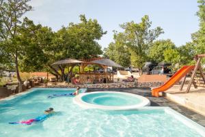 a group of people in a swimming pool at a resort at Krk Mobile Homes in Klimno