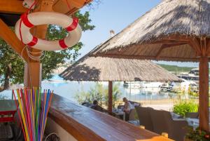 a bar with straw umbrellas and a table with colorfulools at Krk Mobile Homes in Klimno