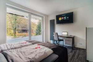 1 dormitorio con cama, escritorio y ventana en Hotel Hafermarkt en Wildemann