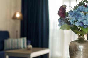 een vaas gevuld met blauwe en paarse bloemen op een tafel bij Melior-1 in Calpe