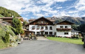 ein großes weißes Haus mit Blumen an den Fenstern in der Unterkunft Alpengasthof Eppensteiner in Navis