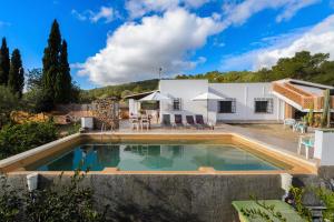 uma villa com uma piscina e uma casa em Villa Davyvic em Sant Joan de Labritja