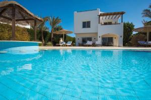 a large swimming pool in front of a villa at Sunset Villa in El Gouna with Private Heated Pool NEW BEDROOMS ADDED in Hurghada