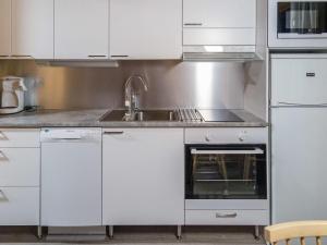 アカスロンポロにあるHoliday Home Lähikaltio 314 by Interhomeの白いキャビネットとシンク付きのキッチン