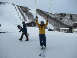 una persona en esquís que se aferra a un remonte en Velle Cottage Village en Hakuba