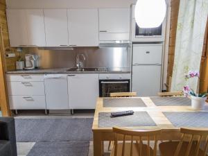 uma cozinha com armários brancos e uma mesa em Holiday Home Lähikaltio 314 by Interhome em Äkäslompolo