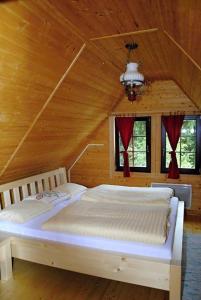 a bedroom with two beds in a wooden cabin at Penzión MLADOSŤ Remata in Ráztočno