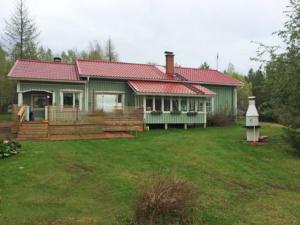 uma casa verde com um telhado vermelho e um quintal em Holiday Home Lehto by Interhome em Jokijärvi