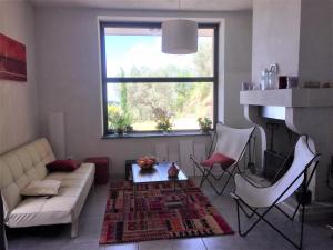 sala de estar con sofá, sillas y ventana en Villa en Nocera Terinese