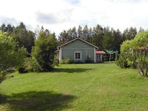 uma pequena casa num quintal com um relvado verde em Holiday Home Lehto by Interhome em Jokijärvi