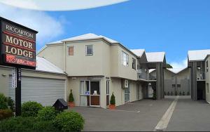 um motel motoren com uma placa e um parque de estacionamento em Riccarton Motor Lodge em Christchurch