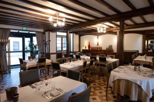 a restaurant with tables and chairs with white tablecloths at Logis Chez Germaine in Geüs-d'Oloron