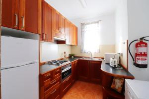 - une cuisine avec des placards en bois et un réfrigérateur blanc dans l'établissement Apartment Esmeralda Meneguina by SpainSunRentals 1121, à Frigiliana
