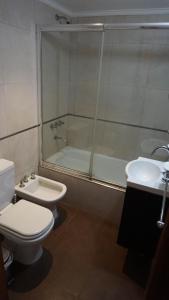 ein Badezimmer mit Toilette, Waschbecken und Badewanne in der Unterkunft casa emilia in Villa Gesell + 8 Fotos