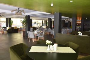 a restaurant with a table with flowers on it at Hotel Bulevard in Râmnicu Vâlcea