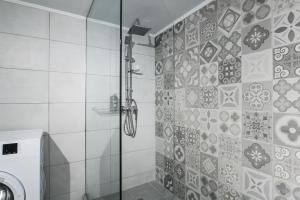 La salle de bains est pourvue d'une douche avec une porte en verre. dans l'établissement Omnia Pagrati Apartments, à Athènes