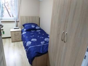 a small bedroom with a bed and a wooden cabinet at Agroturystyka Czerwone Maki 2 Łazienki 5 Pokoi Kuchnia - NoclegiGrodziskPL 792-535-535 in Grodzisk Mazowiecki