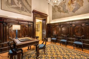 Cette chambre comprend une table, des chaises et un lustre. dans l'établissement Casa Hosteno, à Naples