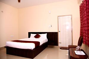 a bedroom with a bed and a chair in a room at The INN in Mysore