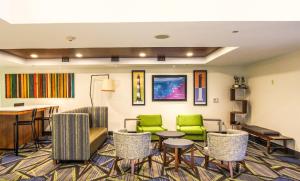a waiting room with green chairs and a table at Holiday Inn Express Hotel & Suites Charleston - North, an IHG Hotel in Charleston