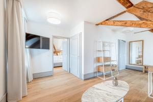 a living room with white walls and wooden beams at Hotel Weissenstein in Oberdorf