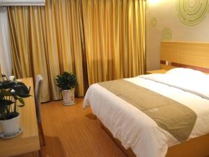 una camera con un grande letto e alcune tende di GreenTree Inn Taizhou Gaogang District Yonganzhou Town Yong'an North Road Express Hotel a Taizhou